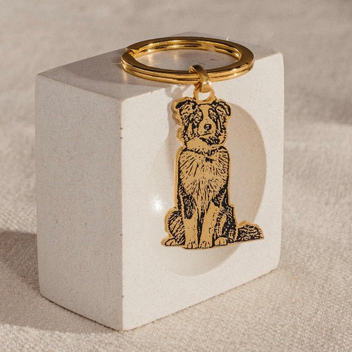 Gold\-tone personalised pet keychain featuring an engraved portrait of a dog, created from a photograph\.