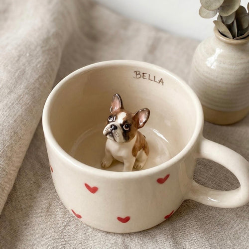 Personalised ceramic pet mug featuring a miniature three-dimensional sculpture of a dog or cat inside the cup.